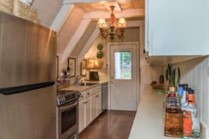 galley kitchen with white base cabinets and brown wood flooring