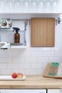brown cutting board hanging over backsplash